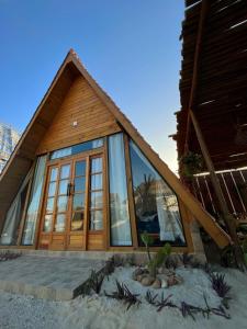 een huis met grote glazen ramen aan het strand bij Solita beach bungalow - kite spot in Macau