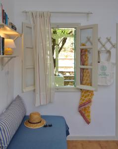 Habitación con ventana y sofá con sombrero en Casa Kalypso, en Steni Vala Alonissos