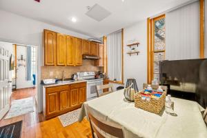 a kitchen with wooden cabinets and a table in a room at New! Charming Home In Heart of City With King Size Bed! in Philadelphia