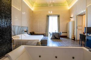 um quarto com uma cama e uma banheira em De Stefano Palace Luxury Hotel em Ragusa