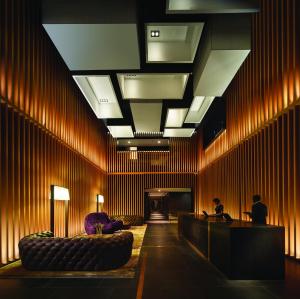 a lobby with wooden walls and couches in a room at G Hotel Kelawai in George Town