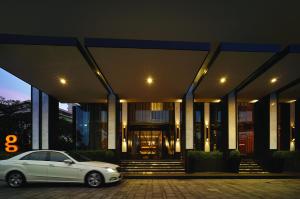 a white car parked in front of a building at G Hotel Kelawai in George Town
