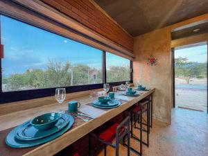 un comedor con una mesa larga con vasos y platos en Amazing 1br loft at La Ventana pool and Best views!, en El Sargento