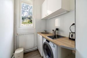 a kitchen with a washing machine and a sink at Studio proche plage in Sainte-Adresse