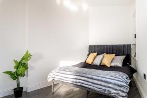 ein Schlafzimmer mit einem Bett mit einer gestreiften Decke in der Unterkunft Stylish Central Studio Apartment Modern Luxury in Brighton & Hove