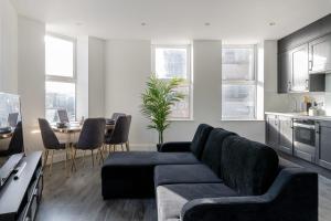ein Wohnzimmer mit einem Sofa und einem Tisch in der Unterkunft Stylish Central Studio Apartment Modern Luxury in Brighton & Hove