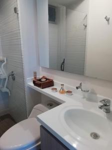 een badkamer met een wastafel, een toilet en een spiegel bij Apartamento en Ricaurte, via a Girardot Relajación Garantizada in Ricaurte