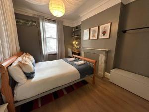 a small bedroom with a bed and a fireplace at Flat espaçoso 3min do metro in London