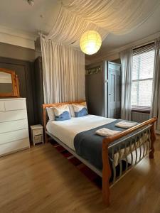a bedroom with a bed and a large window at Flat espaçoso 3min do metro in London