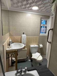 a bathroom with a sink and a toilet and a sink at Flat espaçoso 3min do metro in London
