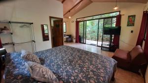 um quarto com uma cama e uma porta de vidro deslizante em Casa Martina em Cahuita