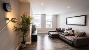 een woonkamer met een bank en een tv bij Stunning Central Apartment In Heart Of Brighton in Brighton & Hove