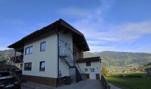 biały budynek ze schodami na boku w obiekcie Appart Mona w mieście Ramsau im Zillertal