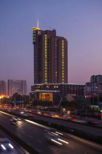Renaissance Wuhan Hotel في ووهان: مبنى كبير مع حركة المرور أمام الطريق السريع