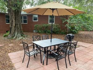 uma mesa e cadeiras com um guarda-sol num quintal em Pack your bags and leave tonight! em Wilmington