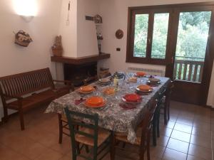 un comedor con una mesa con platos naranjas. en Grande appartamento I Faggi en Abetone