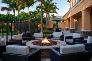 eine Terrasse mit Stühlen und einer Feuerstelle im Innenhof in der Unterkunft Courtyard by Marriott Maui Kahului Airport in Kahului