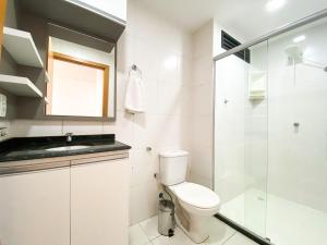 a bathroom with a toilet and a glass shower at Ao lado do Metrô e Shopping (1Qto) in Brasilia