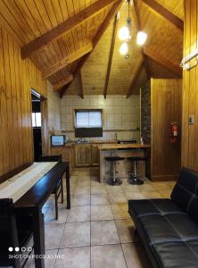 cocina con paredes de madera, mesa y TV en Hotel y Cabañas Pulegan, en Porvenir
