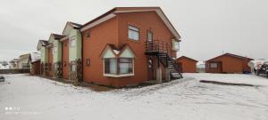 uma casa de madeira na neve num quintal em Hotel y Cabañas Pulegan em Porvenir