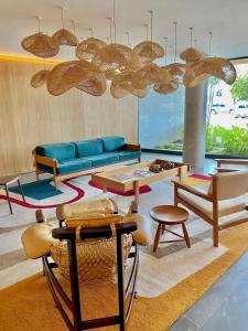 sala de estar con sofá azul y sillas en Flat Av. Atlantica em frente ao mar, estrutura total, en Río de Janeiro