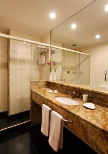 łazienka z 2 umywalkami i dużym lustrem w obiekcie Windsor Copa Hotel w mieście Rio de Janeiro