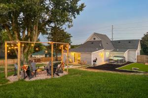 a yard with a house and a backyard with a picnic table at Shelbyville Farmhouse with Hot Tub, Fire Pit and Grill in Shelbyville