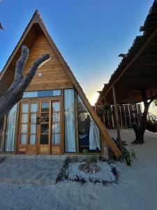 een huis met glazen deuren op een strand bij Solita beach bungalow - kite spot in Macau