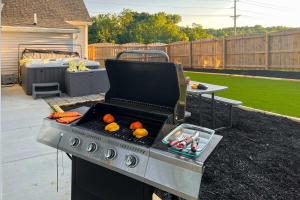 a grill with oranges on it in a backyard at Shelbyville Farmhouse with Hot Tub, Fire Pit and Grill in Shelbyville