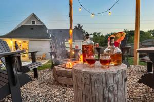 a couple of glasses of whiskey on a stump at Shelbyville Farmhouse with Hot Tub, Fire Pit and Grill in Shelbyville