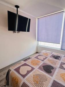 a bedroom with a bed and a window with a quilt at Departamento en Iquique in Iquique
