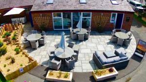 an outdoor patio with tables and chairs and a building at Ty Gwyn park in Abergele