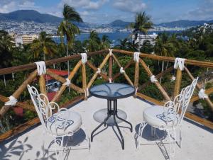 un tavolo e sedie su un balcone con vista sull'oceano di Casa Breizh ad Acapulco