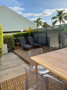 a patio with a wooden table and chairs at 3 bedroom house in Pasito Blanco port, 5 min walk to the beach in Pasito Blanco