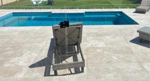 a chair sitting in front of a swimming pool at Sweet Cute blue tiny home with Pool and 2 minute drive to the beach in Wollongong