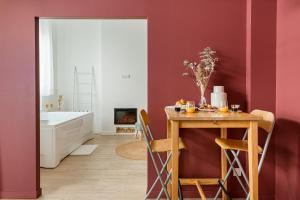 a bathroom with red walls and a table with fruit on it at Suite Évasion Céleste Balnéo et Ciné proche Zénith in Saint-Étienne