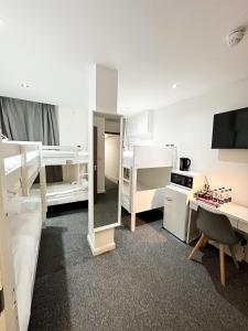 a dorm room with two bunk beds and a desk at 205 Earls Court Rooms in London