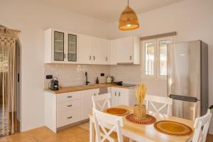 a kitchen with a table and a refrigerator at Anemos house Ios in Ios Chora