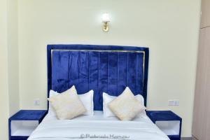 Bett mit blauem Kopfteil und Kissen darauf in der Unterkunft Sandalwood Garden in Nairobi
