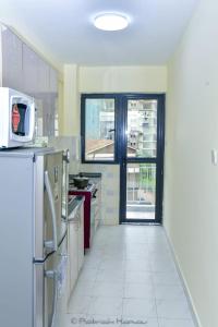 eine Küche mit weißem Fliesenboden und einem Fenster in der Unterkunft Sandalwood Garden in Nairobi