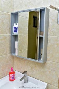 einen Spiegel über einem Waschbecken im Bad in der Unterkunft Sandalwood Garden in Nairobi