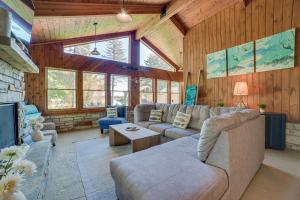 a living room with a couch and a fireplace at Lakefront Kalkaska Cottage with Fire Pit! in Kalkaska