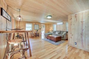 a log cabin living room with a table and a couch at Lakefront Kalkaska Cottage with Fire Pit! in Kalkaska