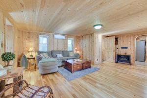 a living room with a couch and a table at Lakefront Kalkaska Cottage with Fire Pit! in Kalkaska