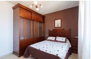 1 dormitorio con 1 cama con cabecero de madera en CASA MARIÑO, en Portosín