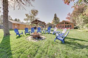 a group of chairs around a fire pit in a yard at Lakefront Kalkaska Cottage with Fire Pit! in Kalkaska