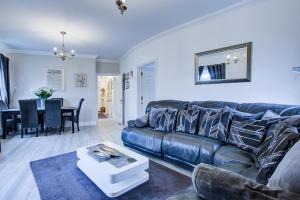 a living room with a leather couch and a table at Modern 2-Bedroom - 2 Bathroom Apartment in Waltham Abbey-Gated Car Park-Fast Internet in Waltham Abbey