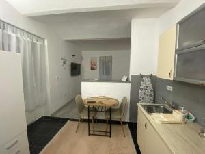 a small kitchen with a table and a sink at Apartmani Sandra in Sarajevo