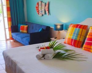 - une chambre avec un lit blanc et un mur bleu dans l'établissement TI OASIS Studio vue Mer dans village Pierre & Vacances, à Sainte-Luce