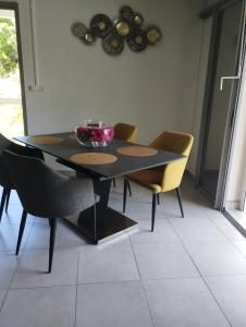 uma sala de jantar com uma mesa preta e cadeiras em VILLA JAGUAR em Le Gosier